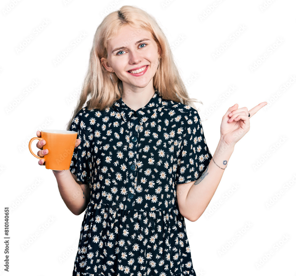 Young caucasian woman drinking a cup of coffee smiling happy pointing with hand and finger to the side Young caucasian woman drinking a cup of coffee smiling happy pointing with hand and finger to the side