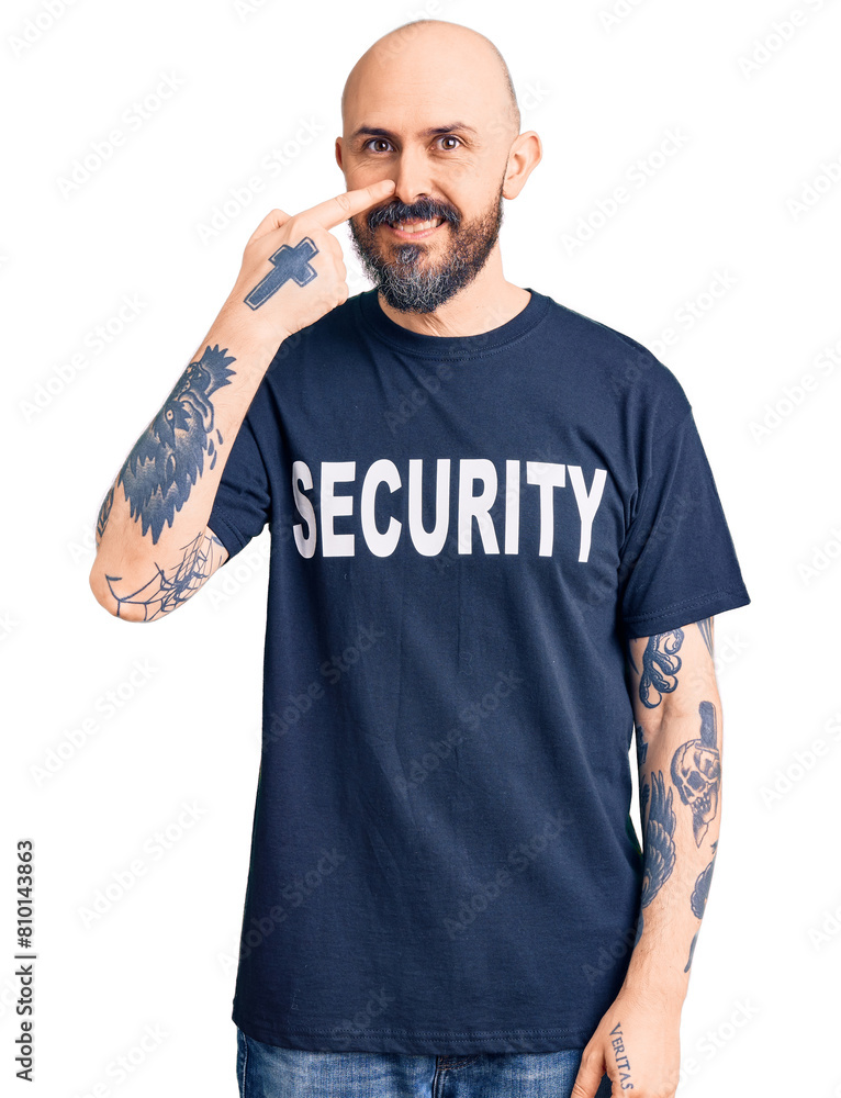 Young handsome man wearing security t shirt pointing with hand finger to face and nose, smiling cheerful. beauty concept Young handsome man wearing security t shirt pointing with hand finger to face and nose, smiling cheerful. beauty concept