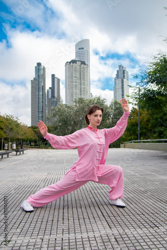 Woman doing Tai chi in city landscape