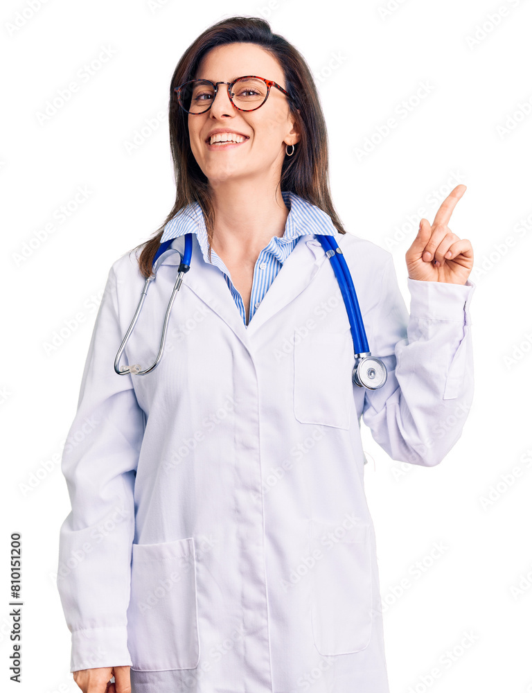 Young beautiful woman wearing doctor stethoscope and glasses with a big smile on face, pointing with hand and finger to the side looking at the camera. Young beautiful woman wearing doctor stethoscope and glasses with a big smile on face, pointing with hand and finger to the side looking at the camera.
