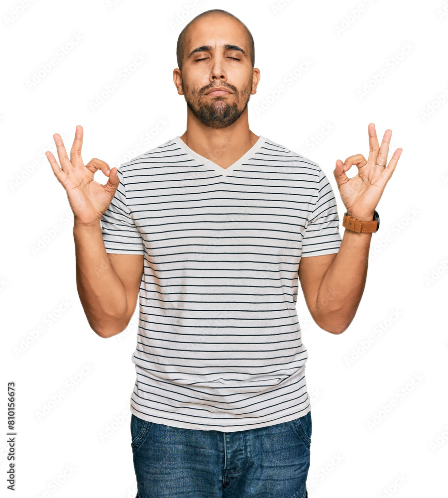 Hispanic adult man wearing casual clothes relax and smiling with eyes closed doing meditation gesture with fingers. yoga concept. Hispanic adult man wearing casual clothes relax and smiling with eyes closed doing meditation gesture with fingers. yoga concept.
