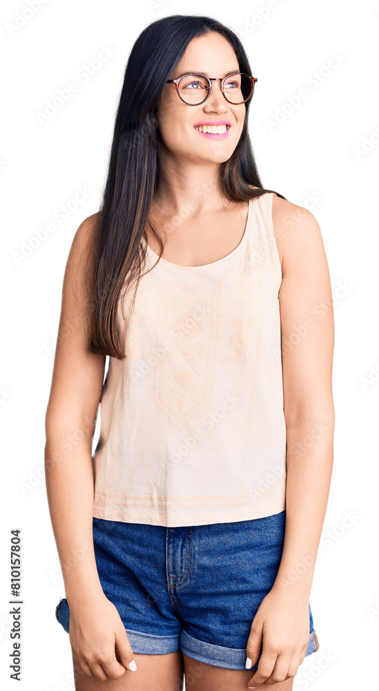 Young beautiful caucasian woman wearing casual clothes and glasses looking away to side with smile on face, natural expression. laughing confident. Young beautiful caucasian woman wearing casual clothes and glasses looking away to side with smile on face, natural expression. laughing confident.