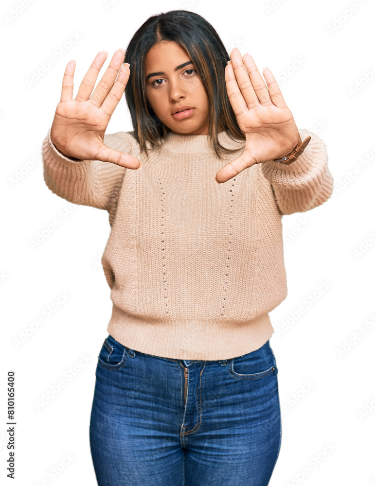 Young latin girl wearing wool winter sweater doing frame using hands palms and fingers, camera perspective Young latin girl wearing wool winter sweater doing frame using hands palms and fingers, camera perspective