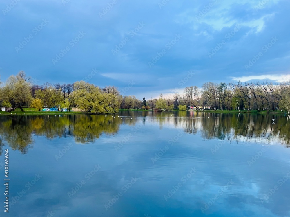 Pond in the park, evening time, trees reflection on the water surface Pond in the park, evening time, trees reflection on the water surface