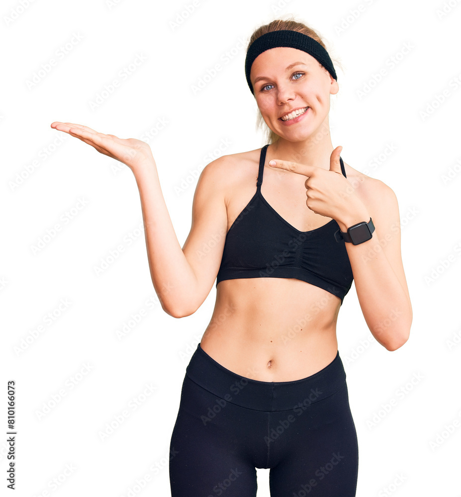 Young beautiful blonde woman wearing sportswear amazed and smiling to the camera while presenting with hand and pointing with finger. Young beautiful blonde woman wearing sportswear amazed and smiling to the camera while presenting with hand and pointing with finger.