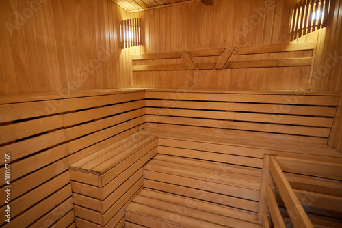 A hardwood sauna with a plank ceiling, brick wall, and stairs © Евгений Вершинин