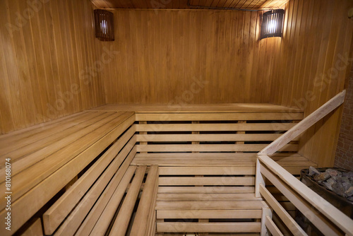 A hardwood sauna with a plank ceiling  brick wall  and stairs