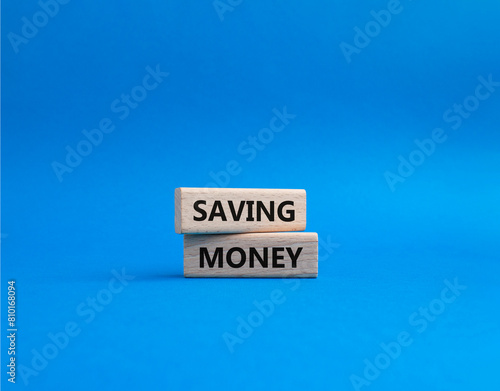 Saving Money symbol. Concept word Saving Money on wooden blocks. Beautiful blue background. Business and Saving Money concept. Copy space
