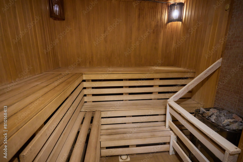 A hardwood sauna with a plank ceiling, brick wall, and stairs A hardwood sauna with a plank ceiling, brick wall, and stairs