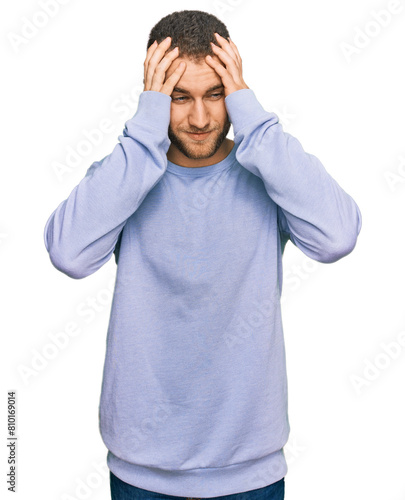 Young caucasian man wearing casual clothes with hand on head for pain in head because stress. suffering migraine.