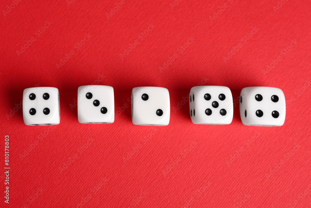 Many white game dices on red background, flat lay Many white game dices on red background, flat lay