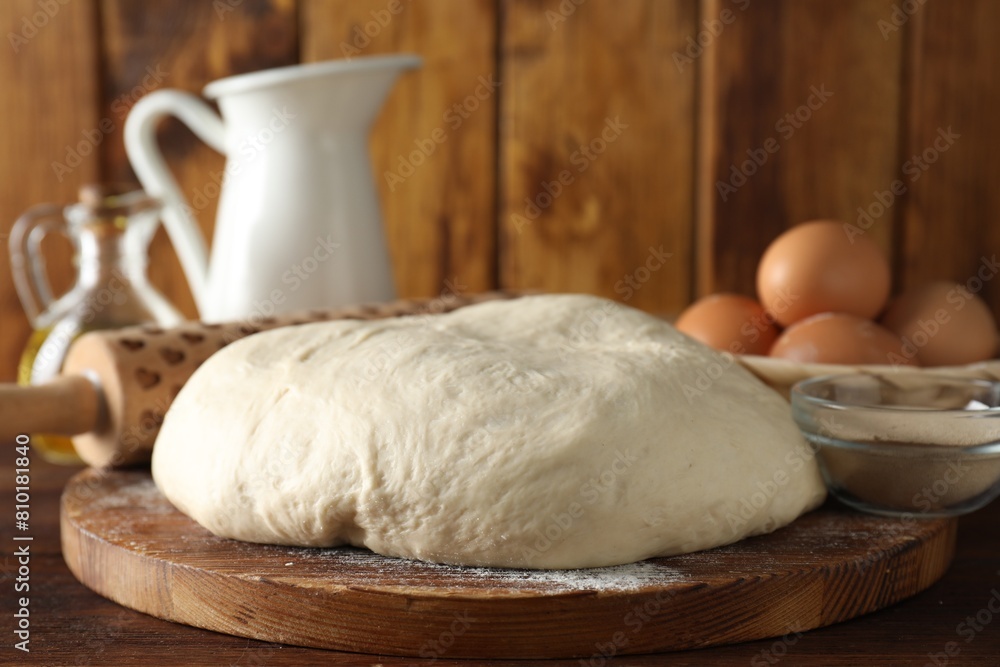Raw dough, rolling pin and ingredients on wooden table Raw dough, rolling pin and ingredients on wooden table