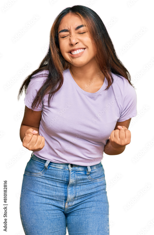 Fototapeta premium Young latin woman wearing casual clothes very happy and excited doing winner gesture with arms raised, smiling and screaming for success. celebration concept.