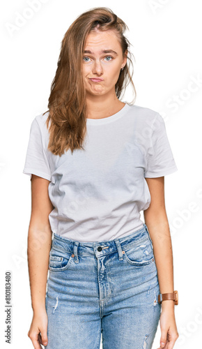 Beautiful young blonde woman wearing casual white t shirt depressed and worry for distress, crying angry and afraid. sad expression.