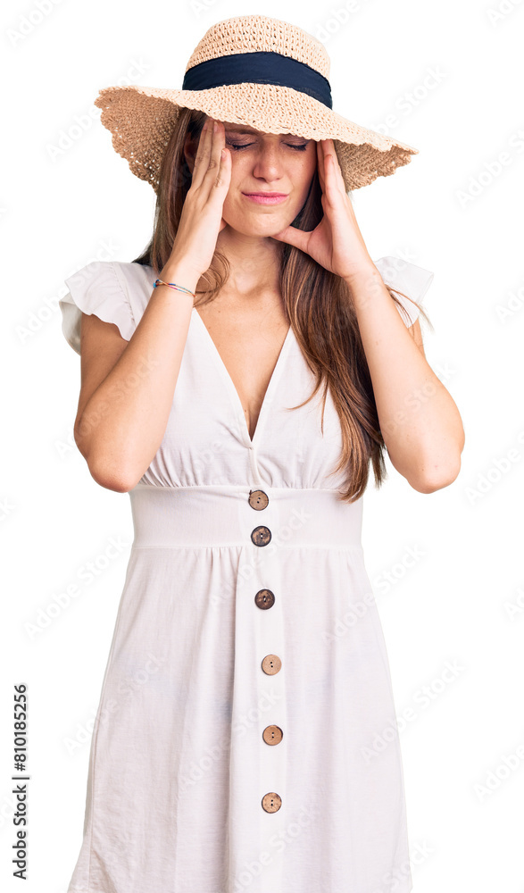 Young beautiful blonde woman wearing summer dress and hat with hand on head for pain in head because stress. suffering migraine. Young beautiful blonde woman wearing summer dress and hat with hand on head for pain in head because stress. suffering migraine.