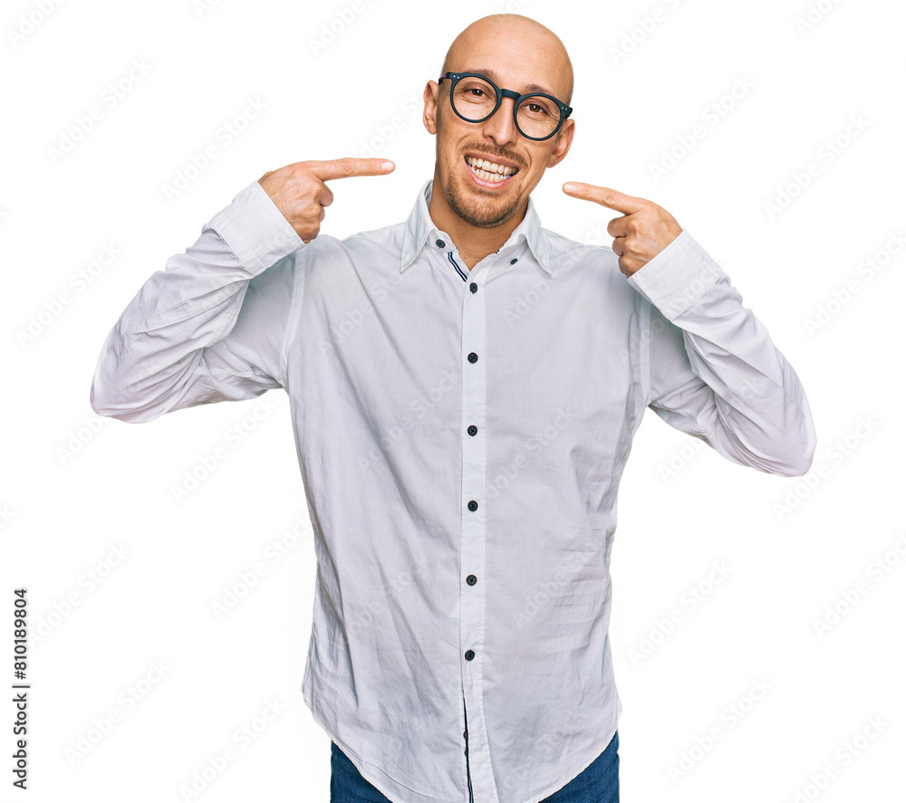 Bald man with beard wearing business shirt and glasses smiling cheerful showing and pointing with fingers teeth and mouth. dental health concept. Bald man with beard wearing business shirt and glasses smiling cheerful showing and pointing with fingers teeth and mouth. dental health concept.