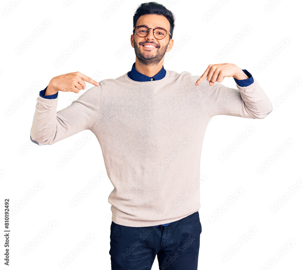 Naklejka premium Young handsome hispanic man wearing elegant clothes and glasses looking confident with smile on face, pointing oneself with fingers proud and happy.