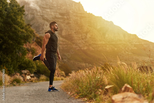 Man  mountain and stretching with headphones in fitness for training  exercise or workout music. Male person  runner and thinking in nature with preparation for balance  sports or podcast for warm up
