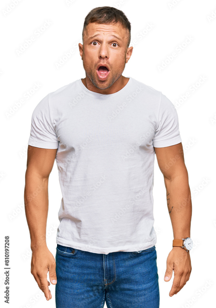 Handsome muscle man wearing casual white tshirt afraid and shocked with surprise and amazed expression, fear and excited face. Handsome muscle man wearing casual white tshirt afraid and shocked with surprise and amazed expression, fear and excited face.
