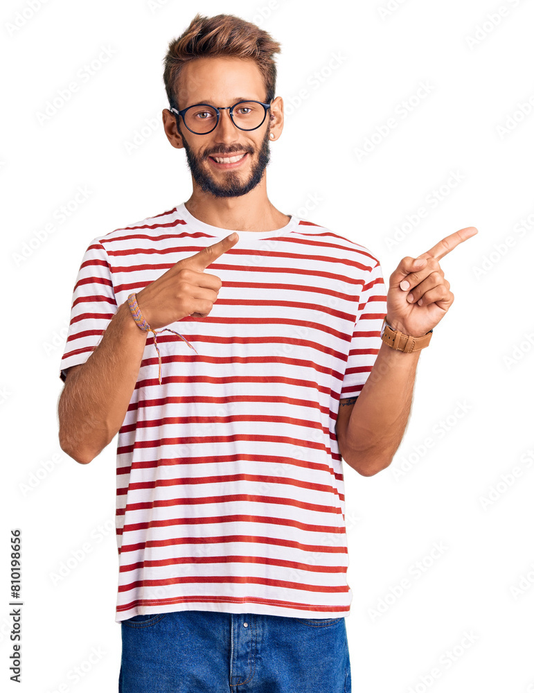 Handsome blond man with beard wearing casual clothes and glasses smiling and looking at the camera pointing with two hands and fingers to the side. Handsome blond man with beard wearing casual clothes and glasses smiling and looking at the camera pointing with two hands and fingers to the side.