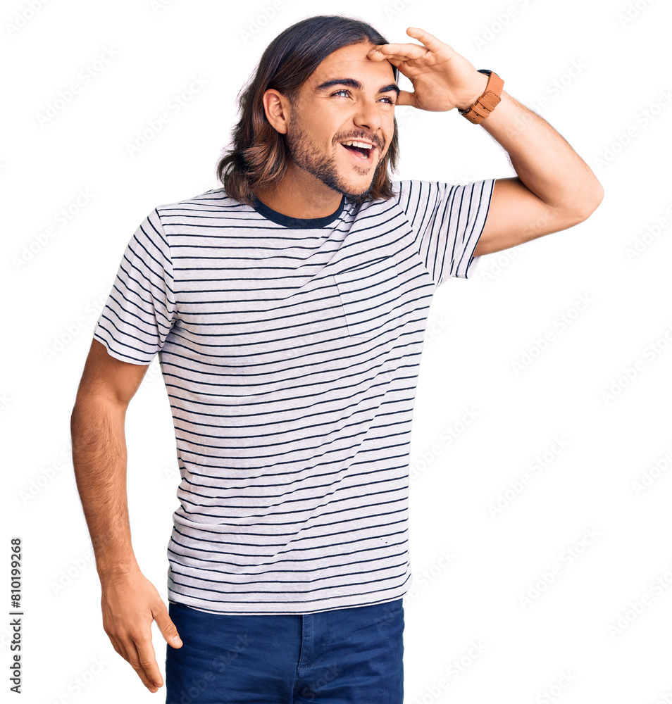 Young handsome man wearing casual clothes very happy and smiling looking far away with hand over head. searching concept.
