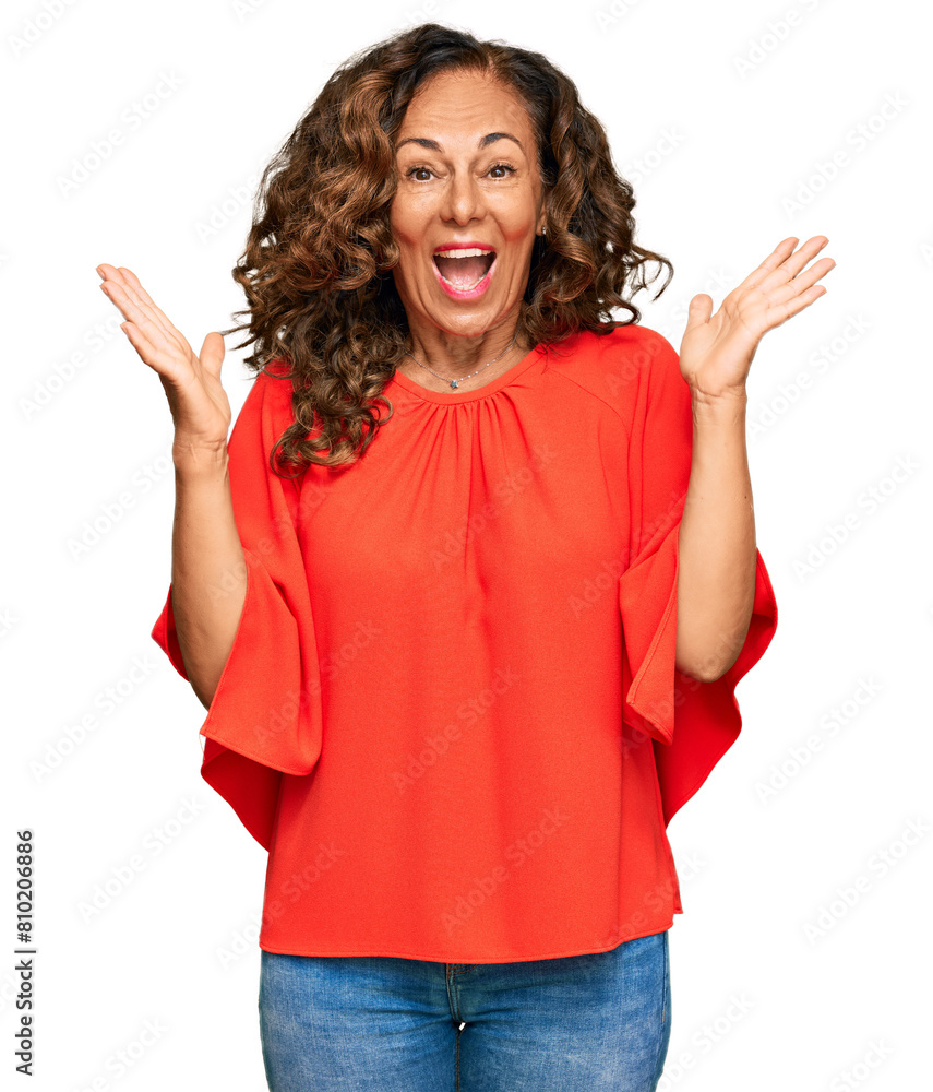 Middle age hispanic woman wearing casual clothes celebrating victory with happy smile and winner expression with raised hands Middle age hispanic woman wearing casual clothes celebrating victory with happy smile and winner expression with raised hands