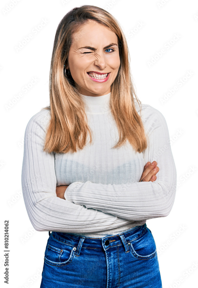 Young blonde woman with arms crossed gesture winking looking at the camera with sexy expression, cheerful and happy face. Young blonde woman with arms crossed gesture winking looking at the camera with sexy expression, cheerful and happy face.