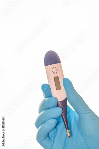 Closeup of a doctor's hand holding a thermometer on white background with copy space on top.