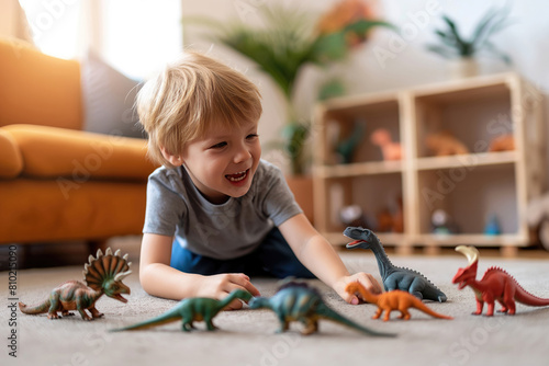 Adorable preschooler boy playing with toy dinosaurs on the floor at home. photo