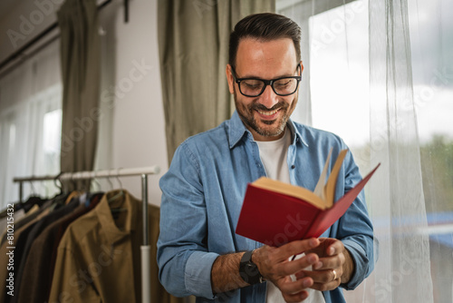 Portrait of adult man read book at living room happy and relax