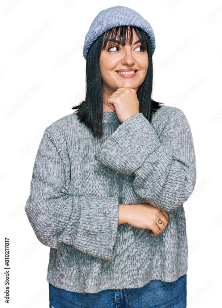 Young hispanic woman wearing cute wool cap with hand on chin thinking about question, pensive expression. smiling with thoughtful face. doubt concept. Young hispanic woman wearing cute wool cap with hand on chin thinking about question, pensive expression. smiling with thoughtful face. doubt concept.