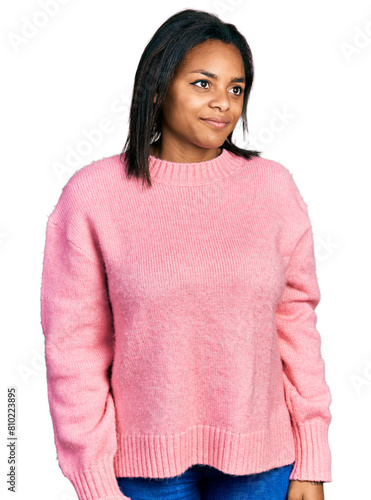 Beautiful hispanic woman wearing casual winter sweater smiling looking to the side and staring away thinking.