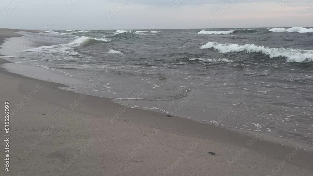 Tranquil view of the sandy coastline of the Baltic Sea with small waves softly breaking on the shore Tranquil view of the sandy coastline of the Baltic Sea with small waves softly breaking on the shore