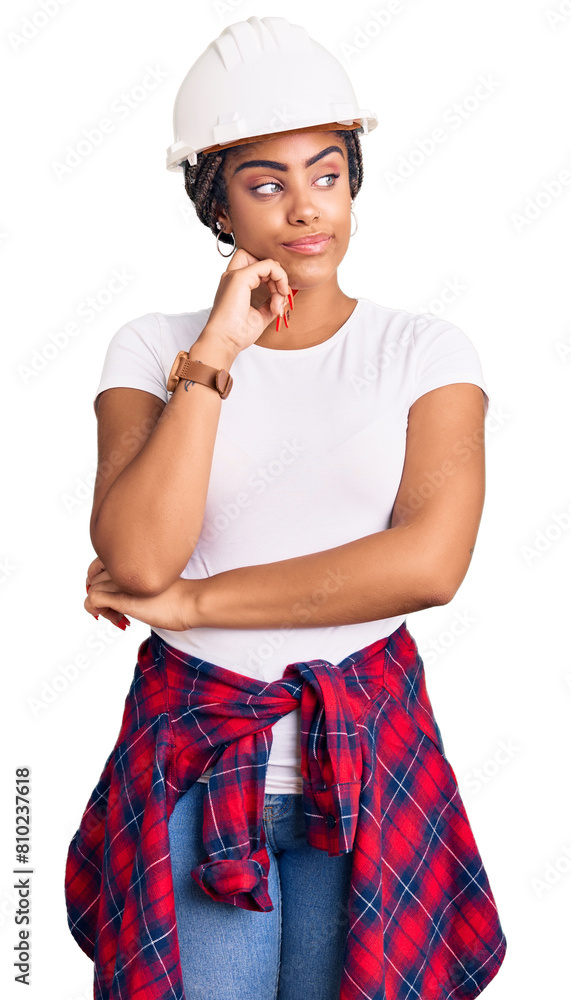 Young african american woman with braids wearing hardhat and builder clothes serious face thinking about question with hand on chin, thoughtful about confusing idea Young african american woman with braids wearing hardhat and builder clothes serious face thinking about question with hand on chin, thoughtful about confusing idea
