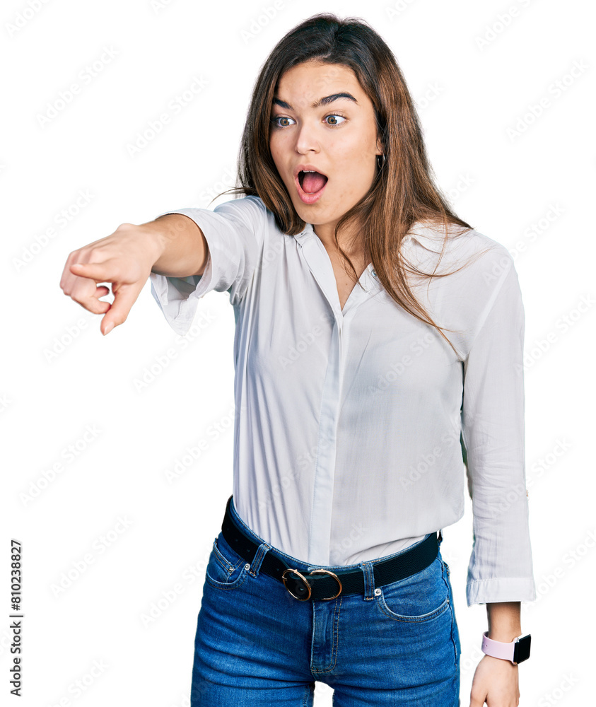 Fototapeta premium Young caucasian girl wearing casual white shirt pointing with finger surprised ahead, open mouth amazed expression, something on the front