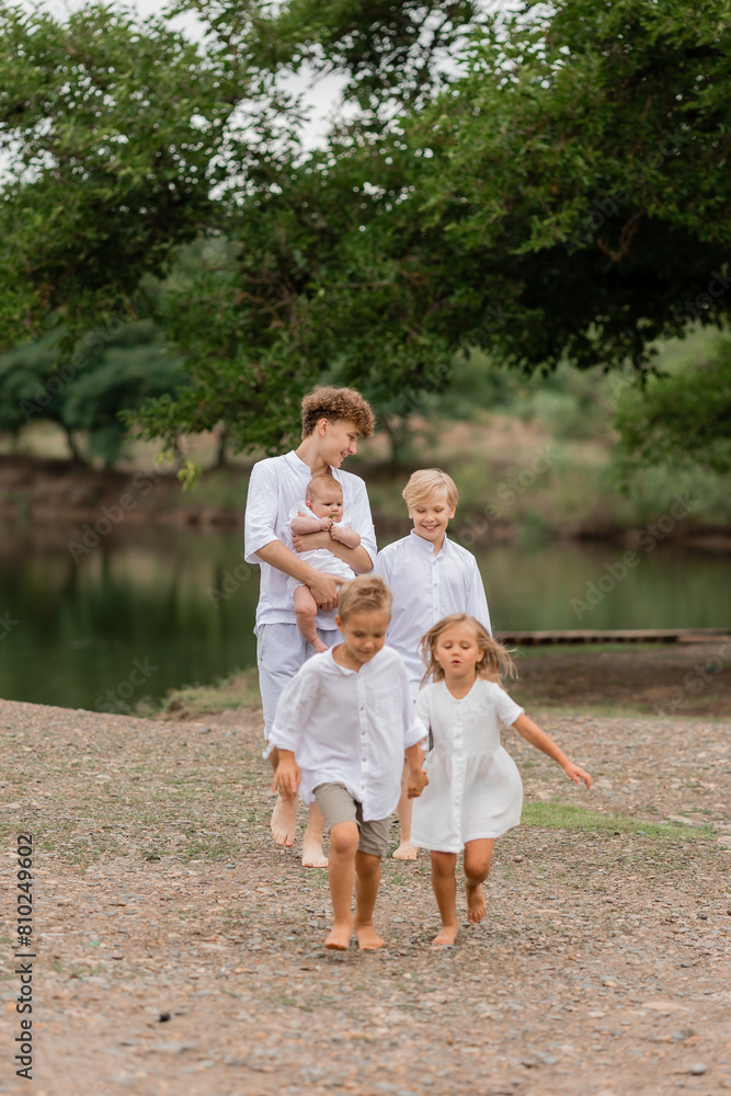 Fototapeta premium children, brothers and sisters walk near the lake in the summer, a large family