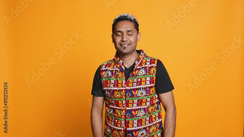 Portrait of narcissistic cheerful indian man celebrating and bragging, showing arrogance. Satisfied person boasting about achievement, cheering and gesticulating, studio background, camera B photo