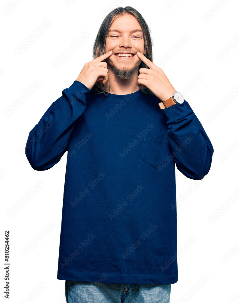Handsome caucasian man with long hair wearing casual winter sweater smiling with open mouth, fingers pointing and forcing cheerful smile Handsome caucasian man with long hair wearing casual winter sweater smiling with open mouth, fingers pointing and forcing cheerful smile