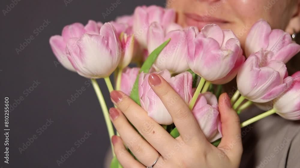 Close up of pink tulip flower bouquet, blurry background with a happy smiling woman Close up of pink tulip flower bouquet, blurry background with a happy smiling woman