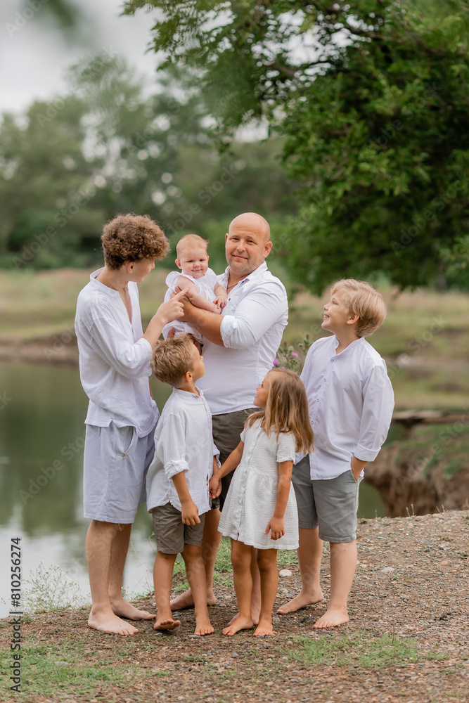 large family walks near the lake in the summer large family walks near the lake in the summer