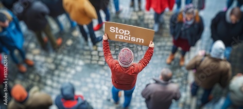 man holding a "Stop Racism" sign, top view