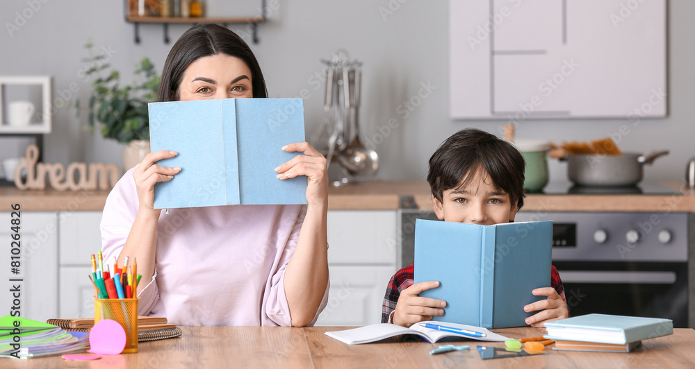 Little boy with his mother doing homework in kitchen Little boy with his mother doing homework in kitchen