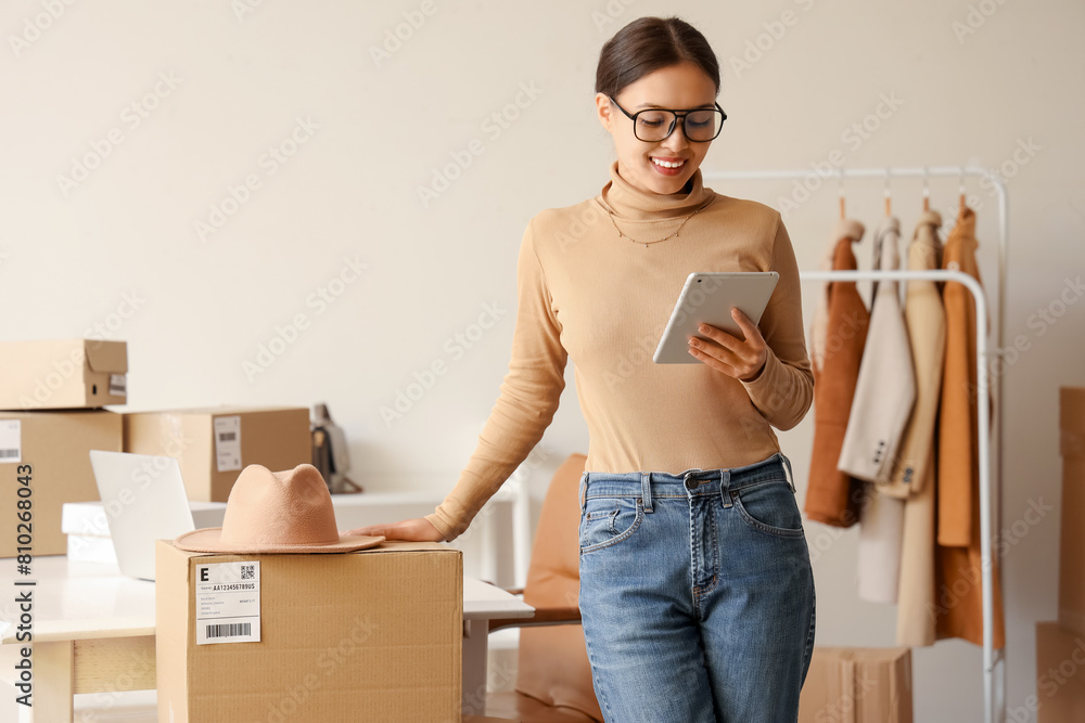 © Pixel-Shot - Female Asian seller with tablet computer in warehouse store