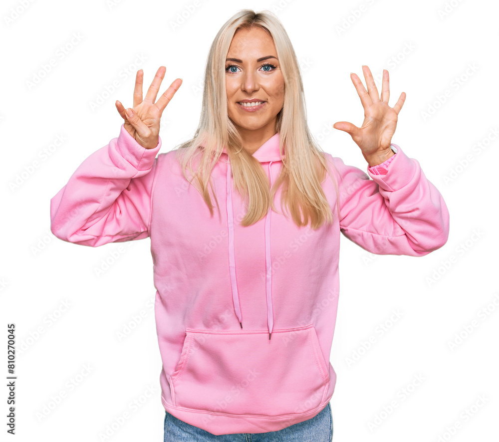 Young blonde woman wearing casual sweatshirt showing and pointing up with fingers number nine while smiling confident and happy. Young blonde woman wearing casual sweatshirt showing and pointing up with fingers number nine while smiling confident and happy.