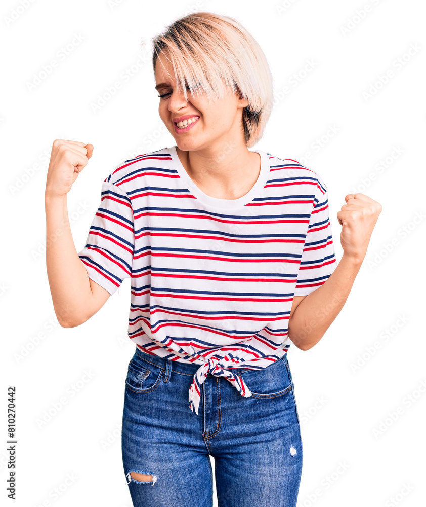Young beautiful blonde woman wearing casual clothes very happy and excited doing winner gesture with arms raised, smiling and screaming for success. celebration concept. Young beautiful blonde woman wearing casual clothes very happy and excited doing winner gesture with arms raised, smiling and screaming for success. celebration concept.