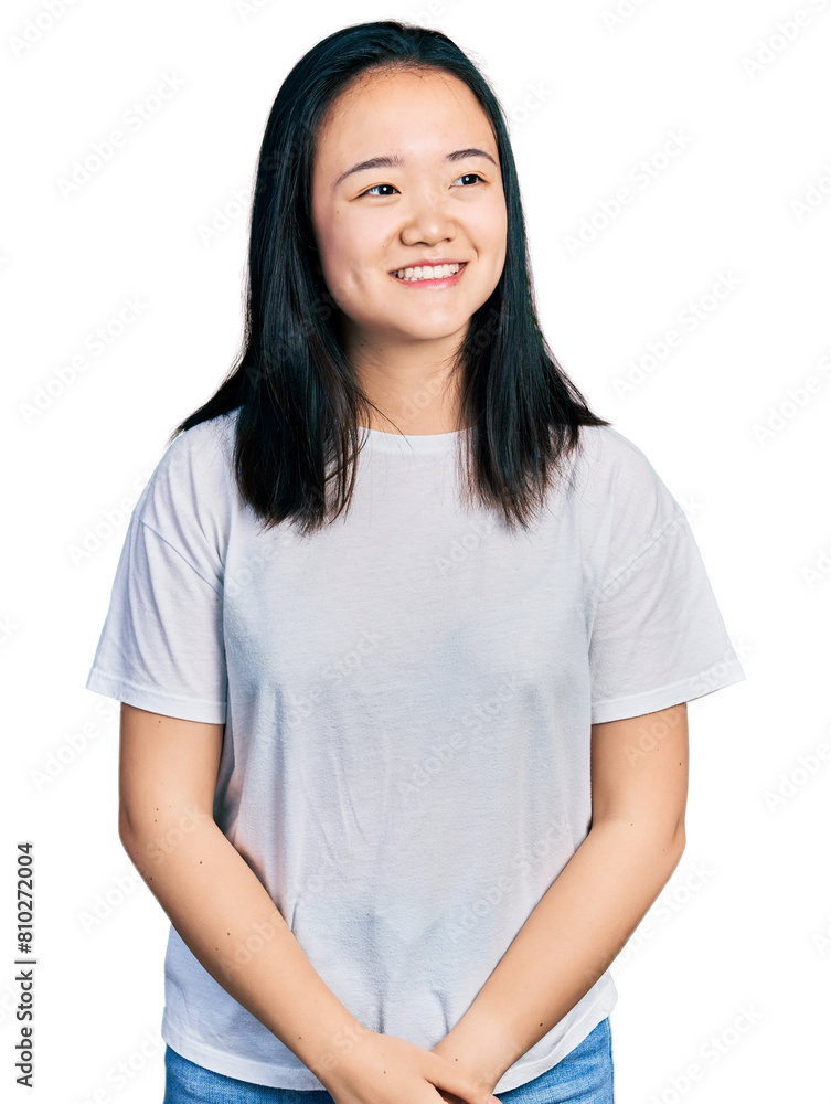 Young chinese woman wearing casual white t shirt looking away to side with smile on face, natural expression. laughing confident. Young chinese woman wearing casual white t shirt looking away to side with smile on face, natural expression. laughing confident.
