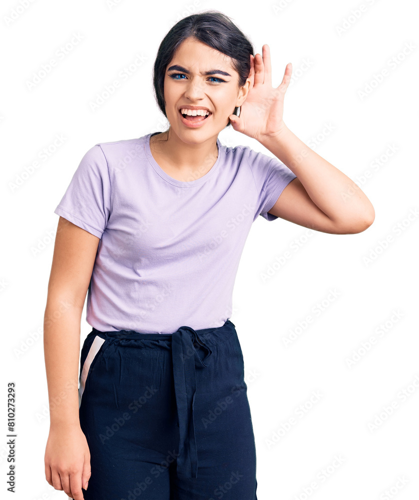 Brunette teenager girl wearing casual clothes smiling with hand over ear listening an hearing to rumor or gossip. deafness concept. Brunette teenager girl wearing casual clothes smiling with hand over ear listening an hearing to rumor or gossip. deafness concept.