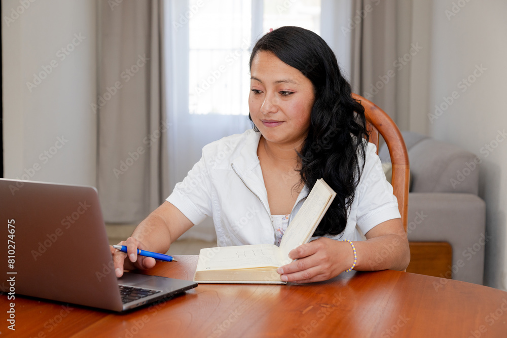 Hispanic woman working from home - remote work - adult woman studying online - working woman with a computer and a work agenda Hispanic woman working from home - remote work - adult woman studying online - working woman with a computer and a work agenda
