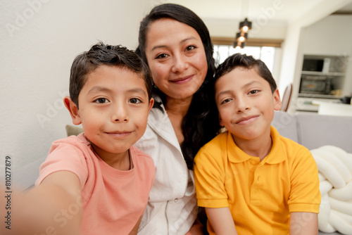 Selfie with mom-mom and Hispanic children taking a photo in the living room-portrait of mother with her children with the phone camera-family photo-single mother-happy mother with her two children