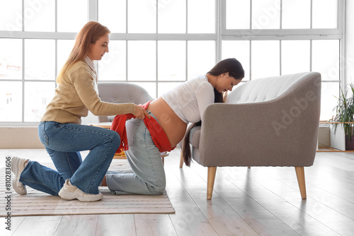 Mature doula massaging youn...